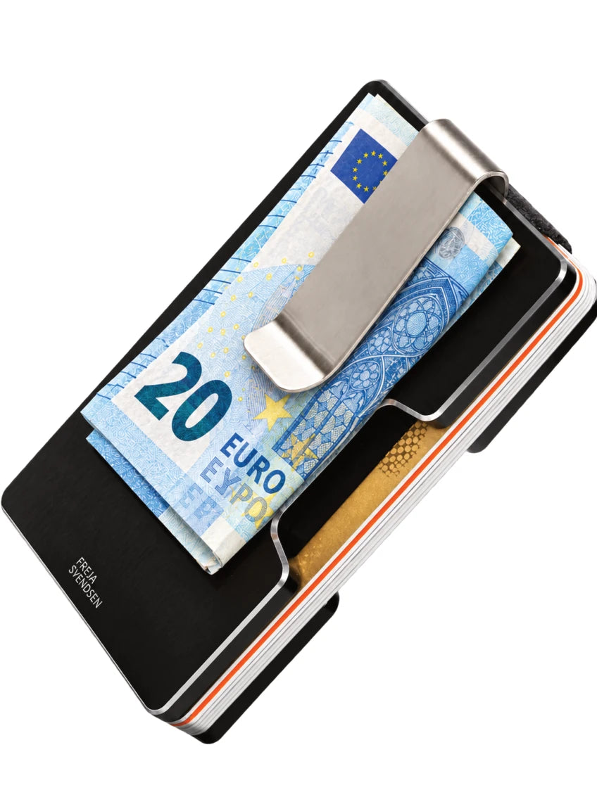 Dos d’un Smart Wallet avec sa pince amovible et des billets pliés.